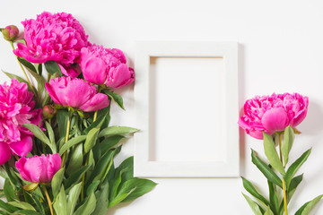 Bouquet of beautiful pink peony flowers and white frame for text on white. Copy space. Top view. Flat lay.