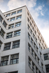 Fragment of a gray high-rise building built in the 1930s of the 19th century, view from below