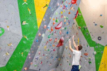 climber explores and develops a route on a climbing wall in the boulder hall