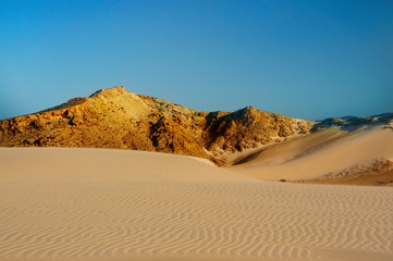 Untouched sand dunes and stormy sky.