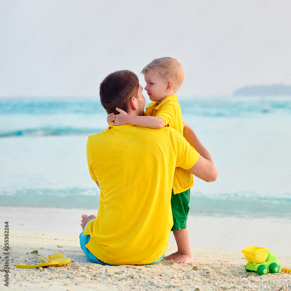 Wall mural toddler boy on beach with father