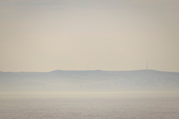 Horizon coastline covered by fog haze background