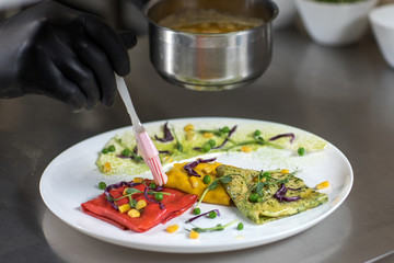 Pancakes of different color on a plate. We prepare with children