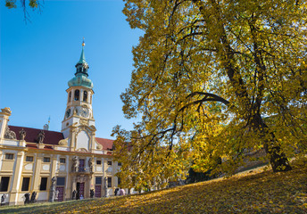 Prague - The Loreto baroque church and autumn tree.