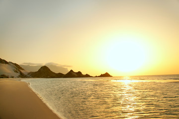 Sunset on a wild beach on the Indian Ocean. Golden sunset on the paradise island beach.