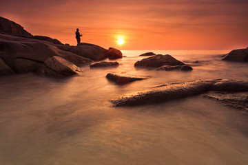 Fototapeta na wymiar silhouette fishing man at the sea during sunset