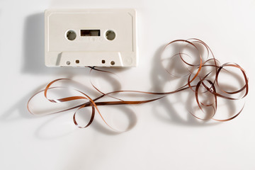 Unraveled cassette tape on white background