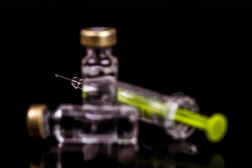 Obraz na płótnie Canvas Medical ampoules and syringe isolated on a black background