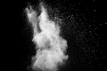 Bizarre forms of white powder explosion cloud against black background.White dust particles splash.