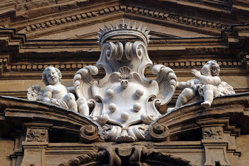 Obraz premium The Medici arms and two angels over the central circular window of Santi Michele e Gaetano church in Florence, Italy