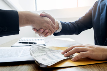 Dealing greeting and partnership meeting concept, businessmen handshaking after finishing up deal contract for both companies.