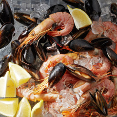 Shrimp with mussels and lemon wedges