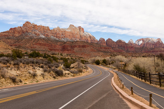Road and bicycle path going through Springdale towards Zion National Park with beautiful mountain peaks in the background, Utah, USA