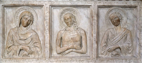 Marble sarcophagus in the Baroncelli Tomb, Florence, sculpted with bas-reliefs with a representation of the Pieta in the Basilica of Santa Croce in Florence, Italy