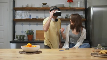 Happy couple, caucasian man putting on vr helmet - Powered by Adobe