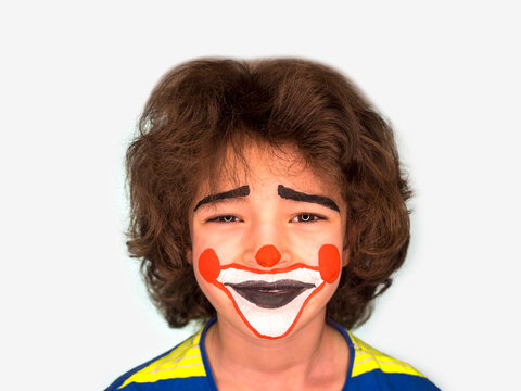 little cute smiling boy with facepaint like clown looking at camera, pantomimic expression. emotions. April Fool's Day, April 1. Isolated on gray