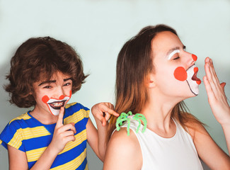 The boy is waiting when his older sister notices the toy spider on her shoulder. The tradition of celebrating the day of the fool concept. Isolated on light background.
