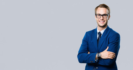 young businessman in glasses, against grey