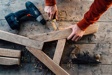 tightening   screw with a screwdriver in the wooden bar, making furniture