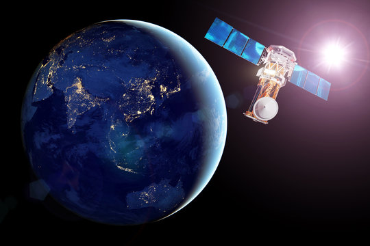 Communication satellite in Earth orbit, view of the night side of the planet, luminous night cities and bright sun. Elements of this image furnished by NASA.