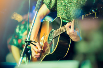 musician's hands playing guitar at a live show on stage