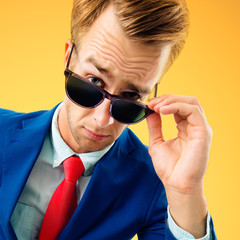 portrait of funny skeptic young businessman in sunglasses