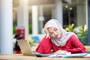Feeling tired. Young asian muslim woman feeling stress from work.
