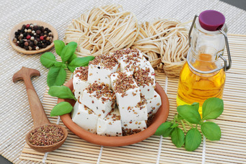 Tofu bean curd dusted with alfalfa seed and ground peppercorns, with olive oil, basil herb & buckwheat noodles.  Health food for vegans. High in protein, omega 3 & containing essential amino acids.