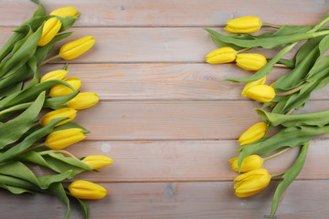 Easter background with yellow tulips on a wooden table