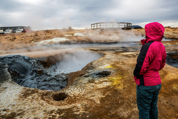 Woman traveler travels to Hverir in Iceland. Hverir (Icelandic: Hverarond) is geothermal area in...