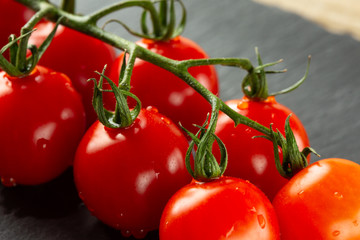 Delicious ripe red tomatoes on their green fresh branch