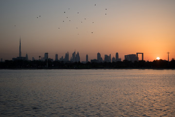 Obraz premium View of the Dubai cityscape at sunset from the Dubai Creek golf & yacht club