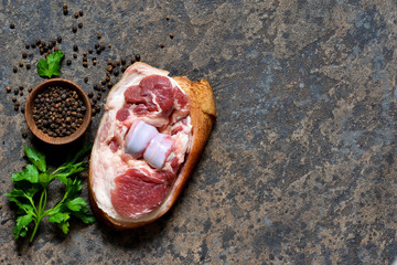 Fototapeta na wymiar Fresh, raw pork steak with bacon and spices on the kitchen stone table. View from above.
