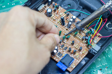 Technician repairing electronic of the computer circuit board by soldering Irons, concept ...