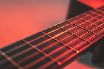 Gitarrenhals mit Gitarrensaiten mit rotem Licht von oben