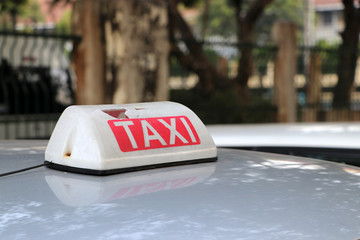 Broken Taxi light sign or cab sign in white and red color with white text on the car roof at the...
