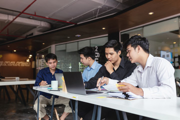Groups of young man who talking together to discuss the work in the workplace.