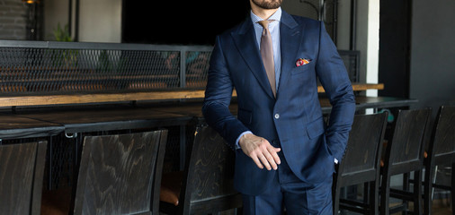 Man in expensive custom tailored suit standing an posing indoors