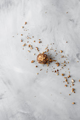 Raw healthy bliss ball with chopped nuts on a textured background with a copy space