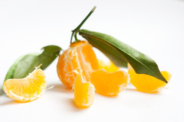 The mandarin without peel with green leafs on white background free space for text isolate