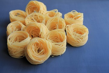 no boiled macaroni nests on blue background.