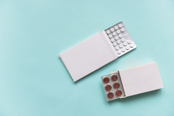 pills medication pills in white paper boxes on an isolated blue background. Doctors and formatsevtsy to cure health in the hospital
