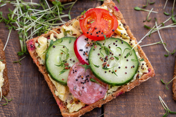 Sandwiches with cream cheese, vegetables and salami.