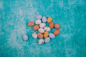 Easter chocolate quail eggs on light blue background.
