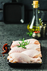 Raw chicken legs, spicy marinated drumsticks in cast iron sheet pan. Selective focus, space for text.