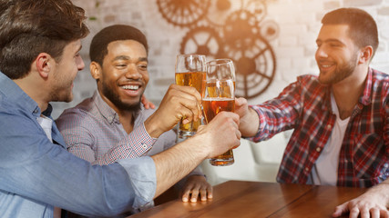 Best friends celebrating meeting, drinking beer in bar