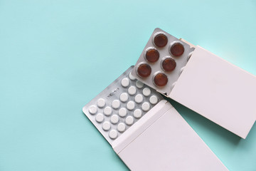 pills medication pills in white paper boxes on an isolated blue background. Doctors and...