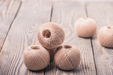 Balls of yarn thread for knitting on a wooden background.