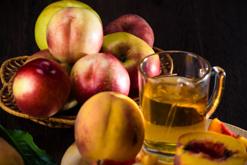 Still life of peaches and juice on a dark background