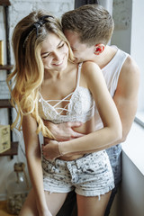 Happy moments together. Happy young couple embracing and smiling at home.